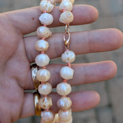 Pearl necklace held in a hand with a blurred background