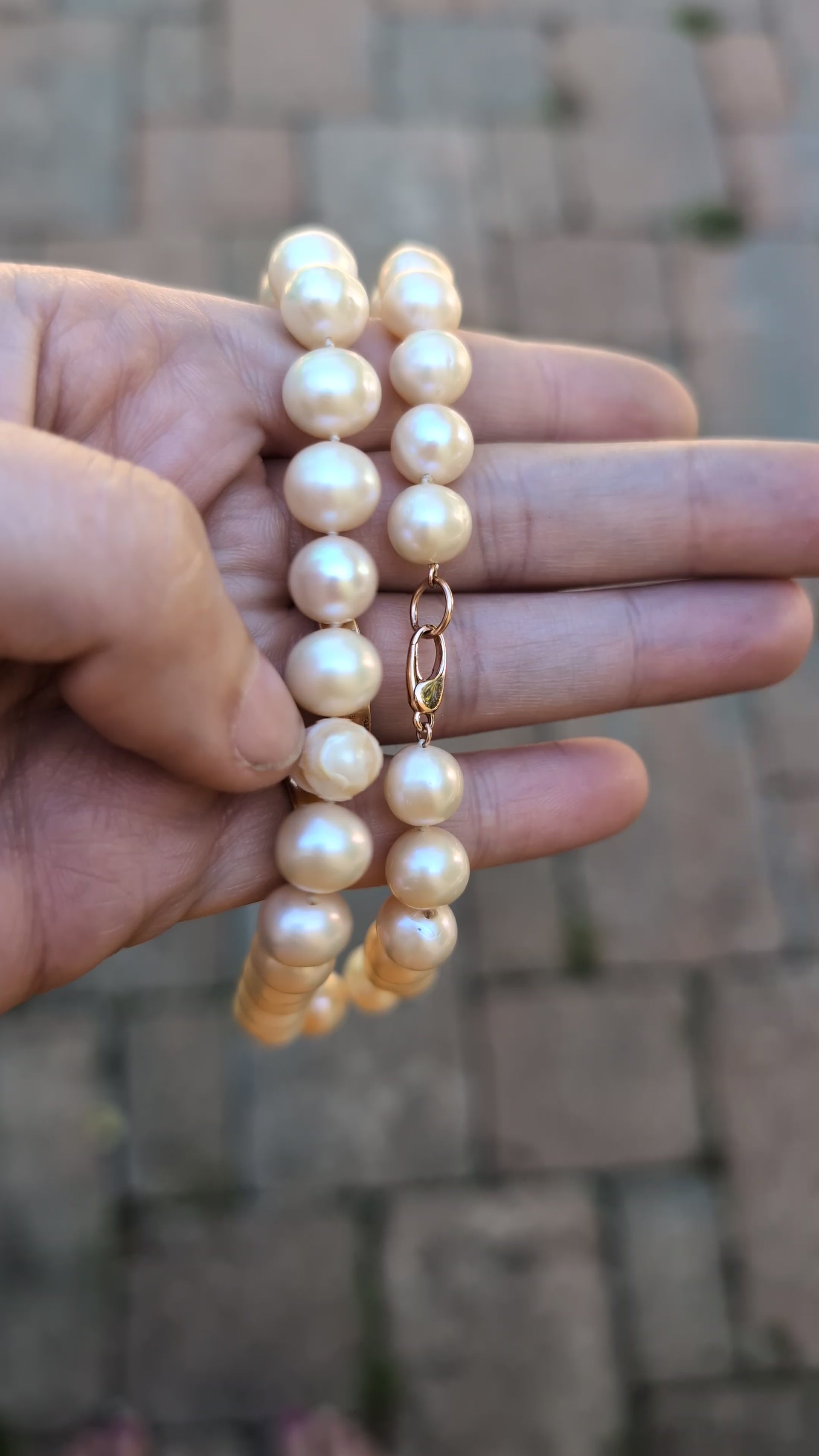 Skull Pearl Necklace in hand on pavement